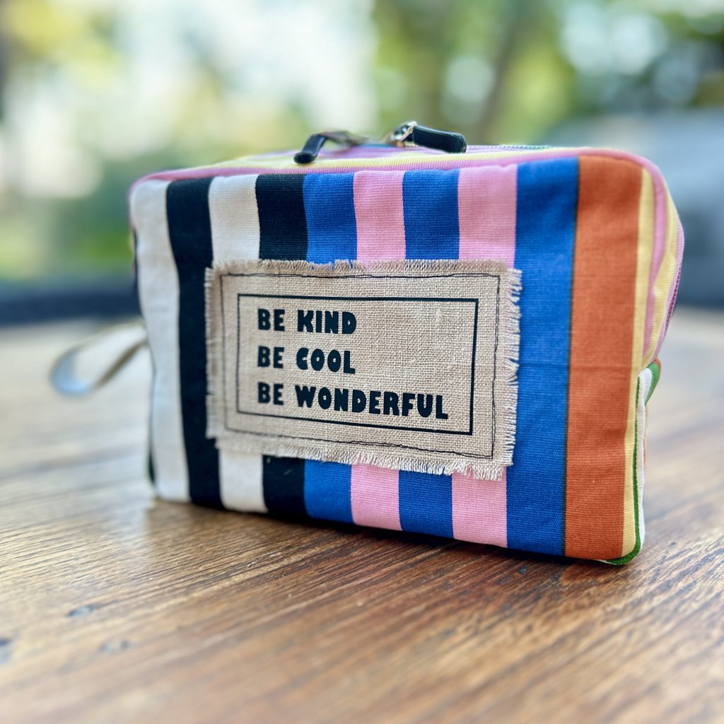 gestreifte Tasche mit Aufnäher und Schrift "Be kind, be cool, be wonderful"