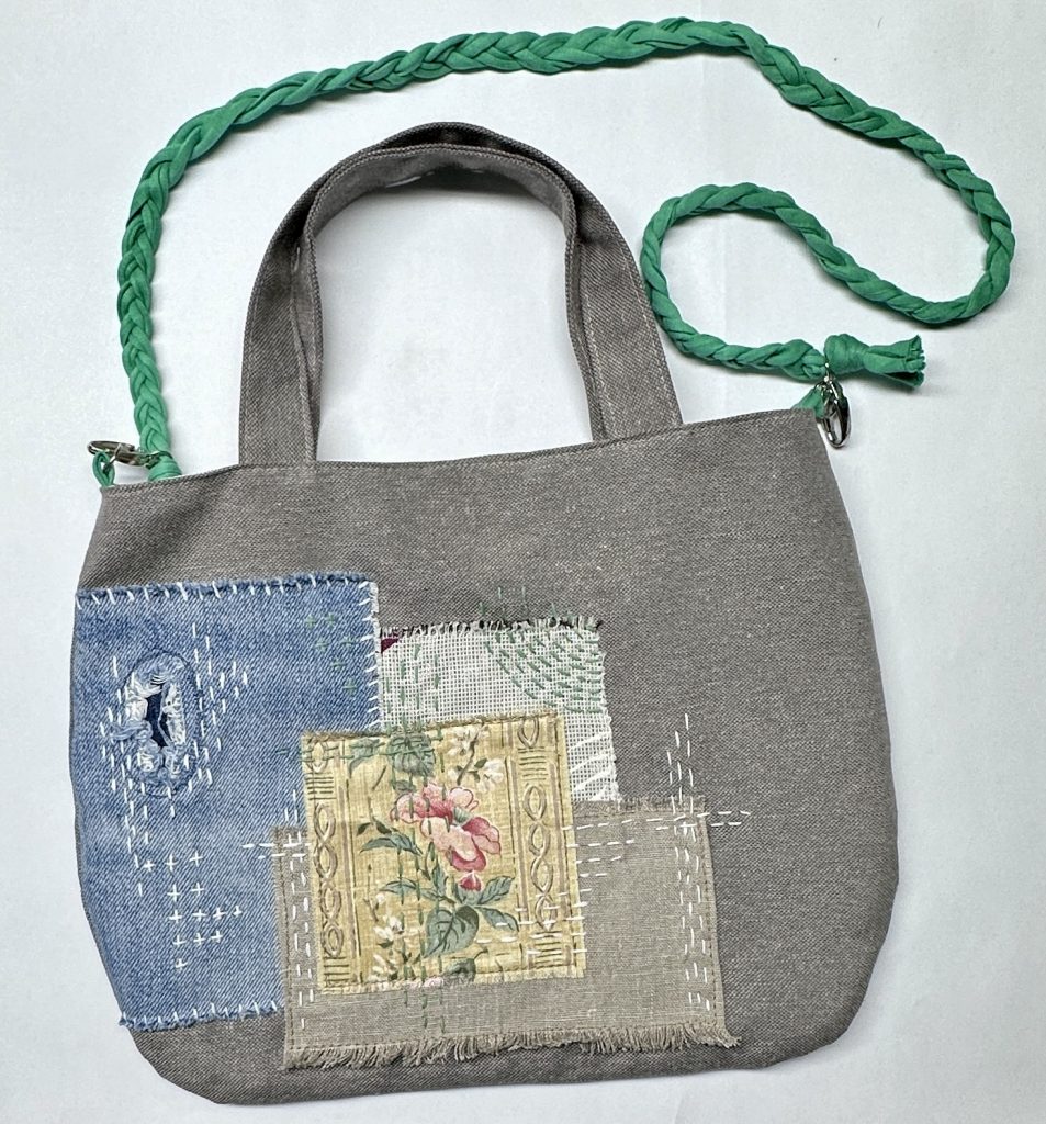 graue Tasche mit Stoffapplikationen und Stickerei